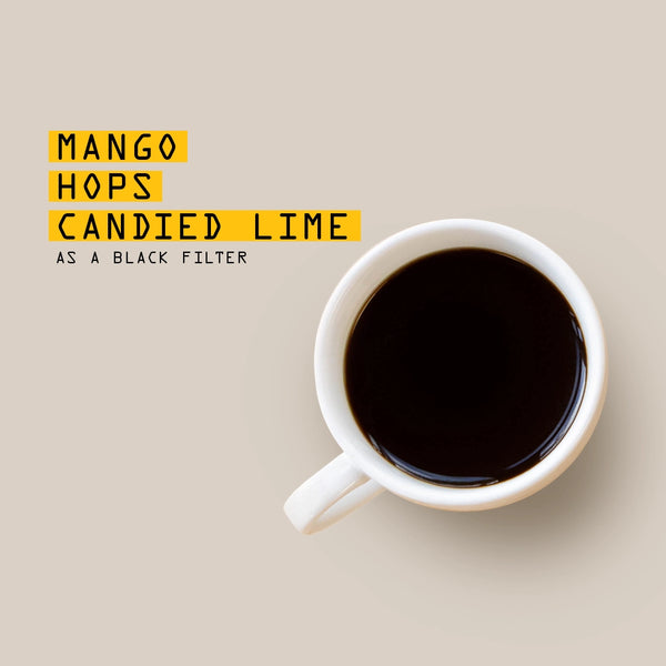 White mug with black coffee on a beige background, text overlay 'Mango Hops Candied Lime as a Black Filter'.
