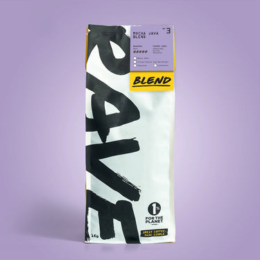 A 1kg bag of Mocha Java Blend Nº 3 sits upright on a purple background. The white packaging displays bold black RAVE text and a yellow label showing 1% for the Planet, highlighting its rich coffee beans.