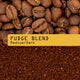 A close-up of whole coffee beans above ground coffee, featuring a yellow label with 