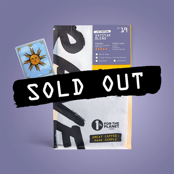 A bag of RAVE COFFEE Daystar Blend Nº 19 with a sun tarot card and SOLD OUT label. Features 1% for the Planet, “Great Coffee, Made Simple,” on purple—enjoy rich Rwandan flavors in every cup.