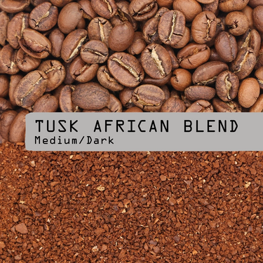 A close-up of whole Rwandan coffee beans above and ground coffee below, divided by a gray label reading Tusk African Blend Nº 24 in bold black text. This medium-dark roast supports conservation efforts.