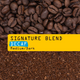 Close-up of whole beans and ground coffee with a yellow label reading Signature Blend Decaf N° 1D. 