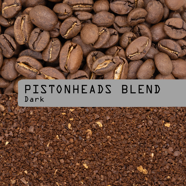 Coffee beans on top and brewed coffee granules below, with a gray label across the center reading 'PISTONHEADS BLEND Dark'.