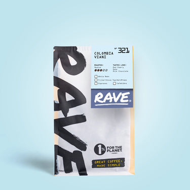 A white and yellow RAVE COFFEE bag labeled Colombia Viani Nº 321 stands on a light blue background, featuring washed Colombian coffee with black cherry and milk chocolate notes. The 1% For The Planet logo is also shown.