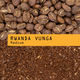 A close-up shows whole coffee beans above ground coffee, separated by a yellow label reading 