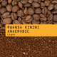A close-up shows whole coffee beans above ground coffee, with a yellow label reading Rwanda Kinini Anaerobic Nº 331 by RAVE COFFEE—highlighting fruit-forward beans from the Kinini Washing Station.