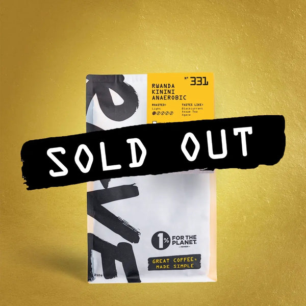 A RAVE COFFEE bag labeled Rwanda Kinini Anaerobic Nº 331 stands against a textured gold background, highlighting its fruit-forward notes from Kinini Washing Station. A bold black strip across the middle reads SOLD OUT in white letters.