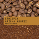 A close-up shows high-altitude Ethiopia Aricha Adorsi Nº 346 beans above and ground coffee below, divided by a tan strip with black text. From RAVE COFFEE—perfect for washed process fans.