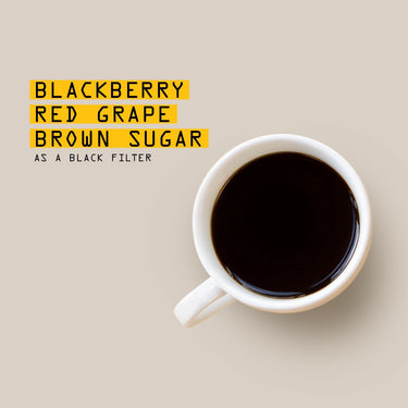 White mug with black coffee on a beige background, tasting notes overlay 'Blackberry, Red Grape, Brown Sugar as a Black Filter'.