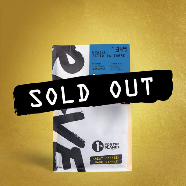 A bag of RAVE COFFEE’s Brazil Sítio da Torre Nº 349 sits against a gold backdrop, boldly marked SOLD OUT. The Obata varietal coffee features the 1% For The Planet logo on its packaging.