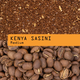A close-up product graphic showing roasted coffee beans at the bottom and ground coffee at the top, with an orange label across the center reading 'KENYA SASINI Medium'.