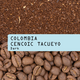 Coffee grounds and coffee beans with 'Colombia Cencoic Tacueyo Dark' label.