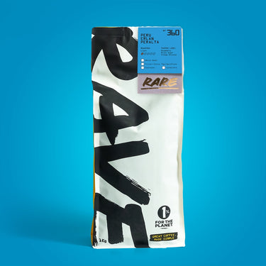 A 1kg bag of Rare Coffee Roastery Peruvian El Pan Pelalta whole bean coffee, standing upright against a solid blue background.