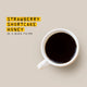 White mug with black coffee on a beige background, text overlay 'Strawberry, Shortcake, Honey'.