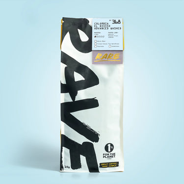 A 1kg bag of 360 Coffee Colombia Fair Trade Washed Medium Roast, featuring a white and black design with a gold accent stripe and a 'RARE' label, set against a light blue background.