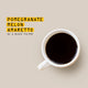 A top-down view of a white ceramic coffee mug filled with black coffee, set against a solid beige background with yellow and black text that reads 'POMEGRANATE MELON AMARETTO AS A BLACK FILTER'.