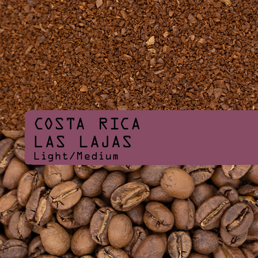 Ground coffee beans labeled 'COSTA RICA LAS LAJAS Light/Medium' with a top layer of dark roasted coffee granules and a bottom layer of whole coffee beans.