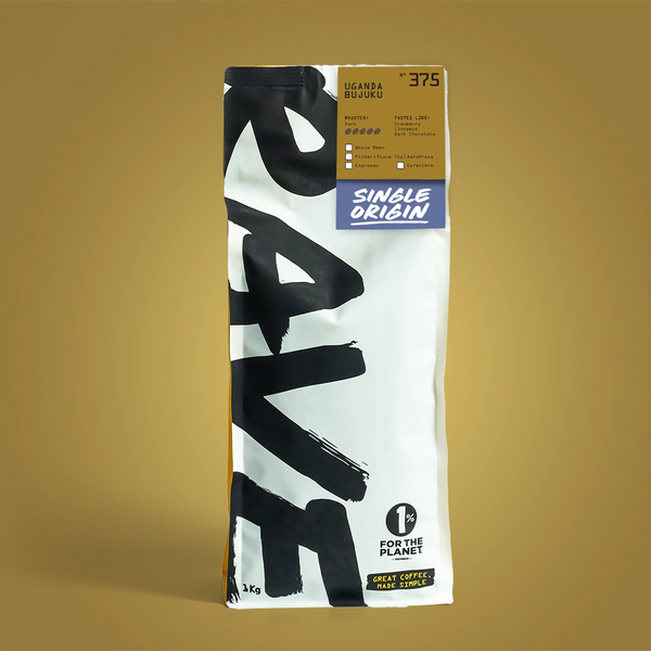 A 1kg bag of Single Origin Uganda Rwego whole bean coffee, featuring a white bag with bold black brushstrokes, a gold top label, and a blue 'Single Origin' logo, set against a solid gold background.