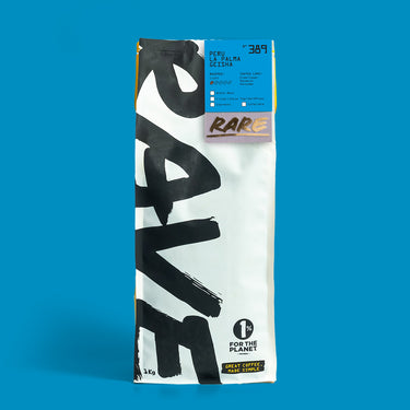 A tall white coffee bag labeled RAVE COFFEE in bold black letters features a blue info label at the top about Peru La Palma Geisha Nº 389, set against a bright blue background.