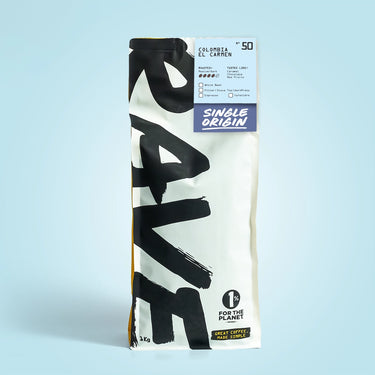 A 1kg bag of Colombia El Carmen Nº 50 single origin coffee. The white bag shows bold black RAVE text, mycotoxin tested details, roast level, producer info, tasting notes, and a 1% for the Planet logo.