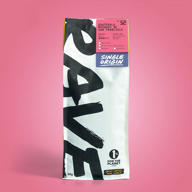 A bag of Guatemala Bosques de San Francisco Nº 52 coffee, with bold black text on white, a pink top label, and “1% for the planet” logo. This balanced sweet coffee offers red apple and toffee notes from Guatemalan beans.