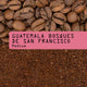 Coffee beans on top and ground coffee below, with a pink label reading Guatemala Bosques de San Francisco Nº 52—ideal for those seeking balanced sweet coffee from renowned Guatemalan farms.