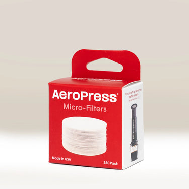 A red and white box labeled AeroPress Coffee Filter papers by Aeropress contains 350 micro filters, showing stacked round filters on the front and an AeroPress coffee maker image on the side.