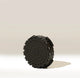 An Aeropress AeroPress Replacement Filter Cap, black and circular with side ridges and raised dots, stands upright on a light background with a shadow underneath.