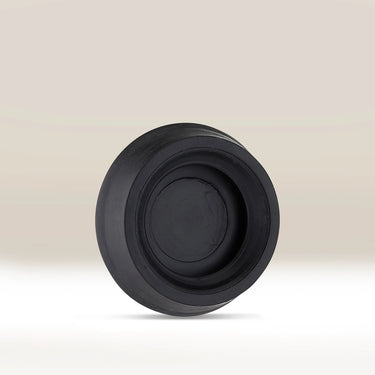 The AeroPress Replacement Rubber Seal by Aeropress, black in color, stands upright on a light, neutral background.