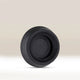 The AeroPress Replacement Rubber Seal by Aeropress, black in color, stands upright on a light, neutral background.