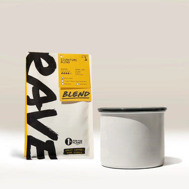 A Rave Branded Airscape with Coffee sits beside a plain white enamel mug with a dark rim and a bag of Rave coffee blend featuring bold black text, all arranged against a neutral background.
