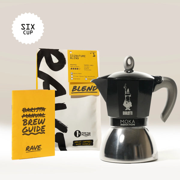 A Bialetti Induction Stove Top Gift Set, featuring a black Italian espresso maker moka pot, a yellow brew guide booklet, and a bag of Rave Signature Blend coffee, is displayed together. A Six Cup label is shown at the top left of the image, highlighting this essential Bialetti set.