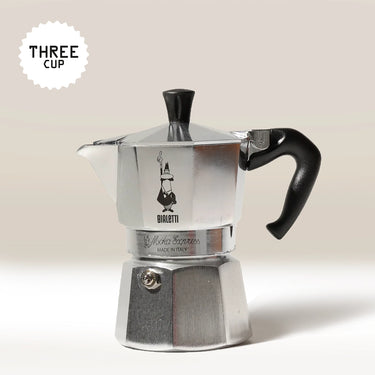 A Bialetti Moka Express Stove Top Coffee Maker in silver, featuring a black handle, is displayed against a plain background. A 