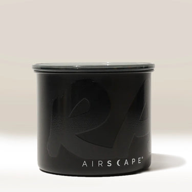 A matte black Branded Airscape Coffee Storage Container by Rave, featuring a fitted lid and AIRSCAPE in white text near the base, is set against a light, neutral background.