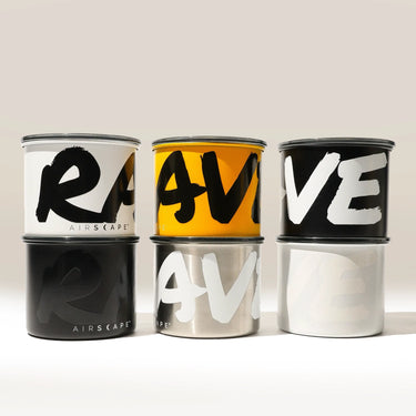 Six Branded Airscape Coffee Storage Containers by Rave are arranged in two rows. Each airtight canister features “RAVE” in bold, stylized letters and comes in black, yellow, silver, or white.