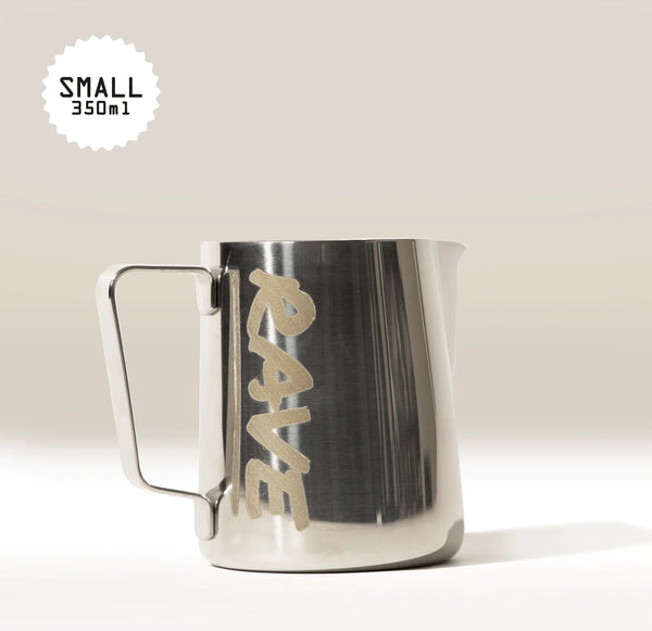 The Rave Milk Jug by RAVE COFFEE is a metallic milk frothing jug featuring the brand’s name, “RAVE,” on the side, along with a corner label that reads “SMALL 350ml.” Essential for barista accessories, this jug has a sturdy handle and precise spout—ideal for pouring silky microfoam. It is displayed against a neutral background.