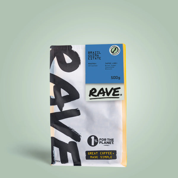 A 500g bag of RAVE COFFEE Brazil Guima Estate Green Coffee Beans for home roasting, with bold black text, a blue top label, 1% for the Planet logo, and a light gradient background.