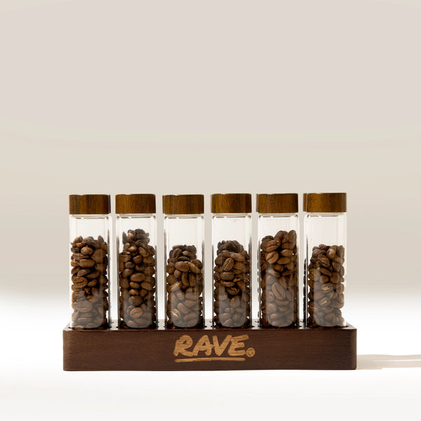 Six Coffee Bean Dosing Tubes filled with beans and topped with wooden lids, standing in a wooden coffee station organizer.