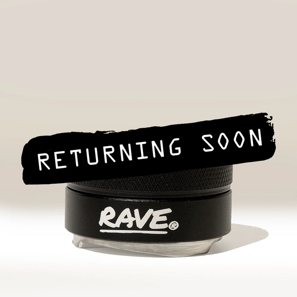 A black container labeled RAVE Coffee features a bold black brushstroke overlay with “RETURNING SOON” in white text, set against a plain beige background—ideal for those seeking consistent extraction using the Rave 54mm Espresso Distributor.