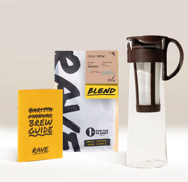 The Hario Cold Brew Gift Set by Hario includes a glass cold brew coffee pot, a bag of Rave Coffee’s cold brew blend for making fresh cold brew concentrate, and a yellow brew guide booklet. Beautifully arranged on a light surface with a neutral background, this gift set is the ultimate choice for any cold brew enthusiast.