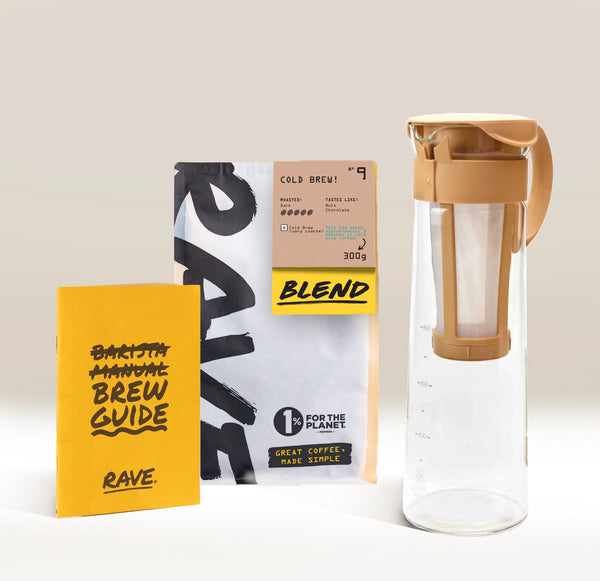 The Hario Cold Brew Gift Set by Hario is an ideal present for coffee lovers, including a yellow brew guide booklet, a bag of Rave cold brew coffee, and a clear Hario Cold Brew Pot with a tan lid and filter.