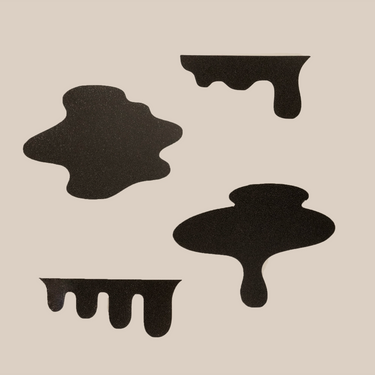 Four irregular black ink blot stickers, illustrated by Rob Griffiths for RAVE COFFEE, feature smooth edges and dripping forms, arranged on a light beige background.