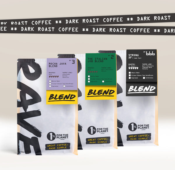 Three colorful Ravecoffee bags stand upright, each featuring a unique blend—Mocha Java, The Italian Job, and Strong AF. "Dark roast coffee" is repeated in the background, highlighting the Dark Roast Bundle for strong coffee lovers.