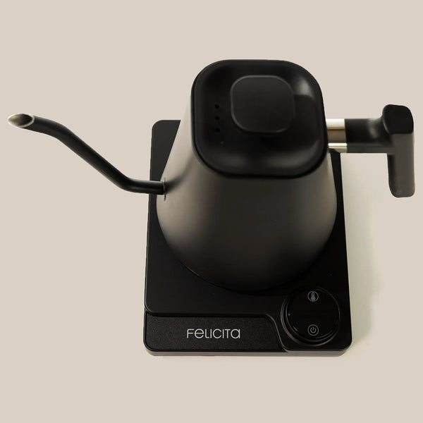 The Felicita Square Pour Over Electric Kettle is a modern black kettle with a gooseneck spout, a matching square base with touch controls, and precision temperature control, featuring the Felicita brand name on the front.