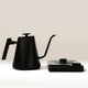 The Felicita Square Pour Over Electric Kettle by Felicita, in matte black with a sleek gooseneck spout and rectangular base, features precision temperature control and a minimalist design with clean lines on a neutral background.