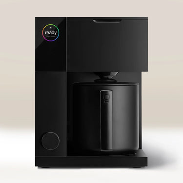 The Fellow Aiden Precision Drip Filter Coffee Maker by Fellow features a modern black design, a circular top-left display with colorful 