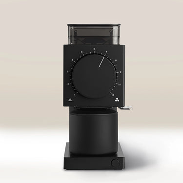 The Fellow Ode Brew Grinder Gen 2 by Fellow is a sleek black grinder with Gen 2 Brew Burrs, a large numbered dial, a clear top bean hopper, and a cylindrical grounds container, all shown on a light beige background.