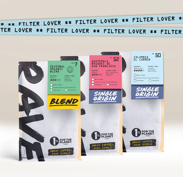 Three Ravecoffee bags from the Filter Lover Coffee Bundle, each with bold "RAVE" text and colorful labels: Seasonal Organic Blend, Guatemala Sugarcane San Francisco, and Colombia El Carmen. A blue strip displays "FILTER LOVER.