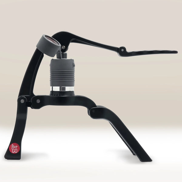 The Flair GO Portable Lever Espresso Maker by Flair features a black frame, lever arm, and gray brewing chamber, making it the ideal compact and portable espresso machine for coffee lovers on the go.