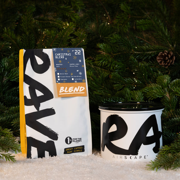 A bag of fresh roasted coffee next to a Branded Airscape with Coffee canister in front of a Christmas tree.